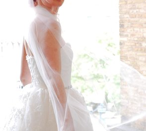 Vit klänning i spets och tyll med strassbälte för bruden.